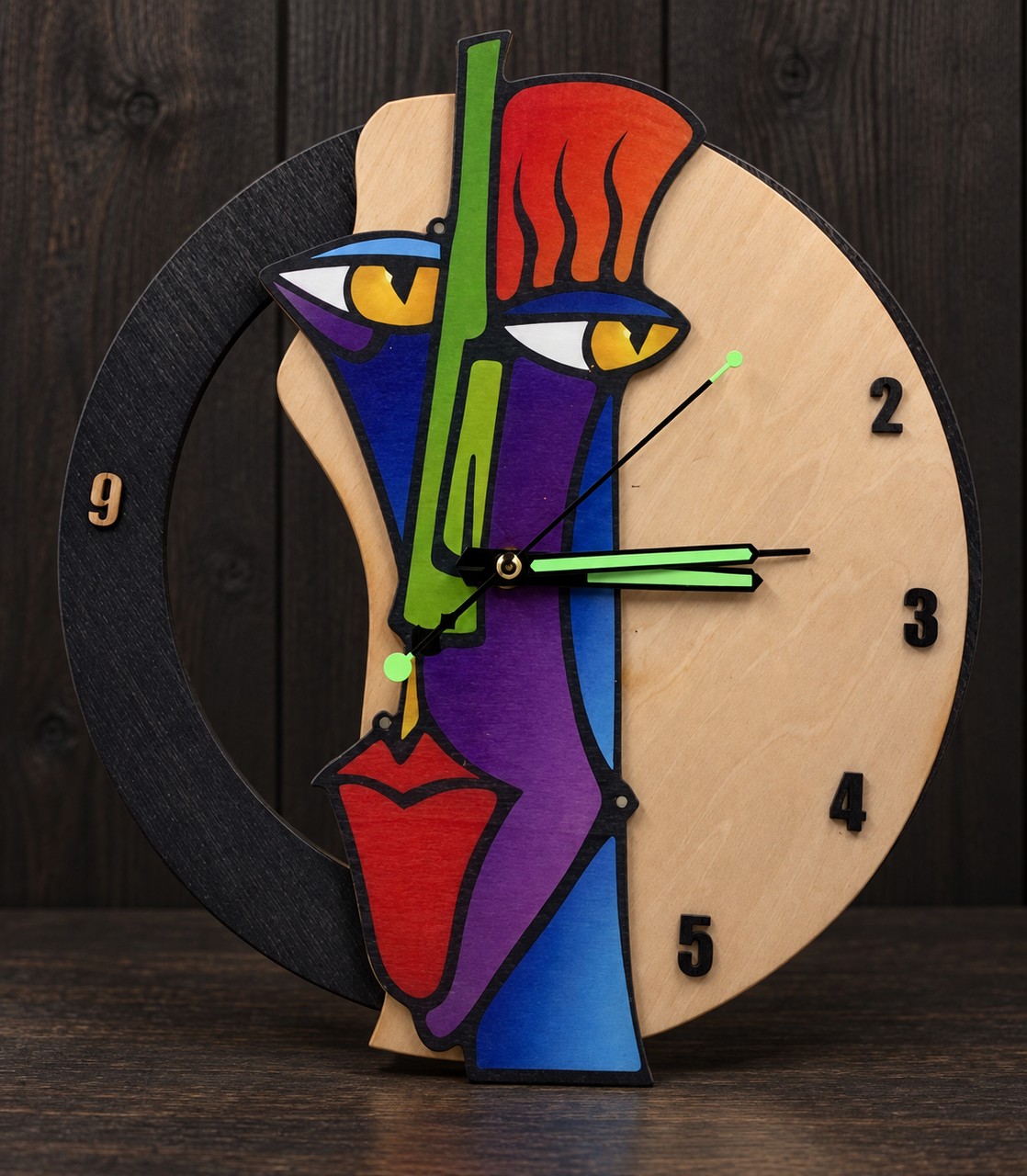 Référence HO 4 — horloge en bois en forme de visage abstrait coloré sur fond studio sombre